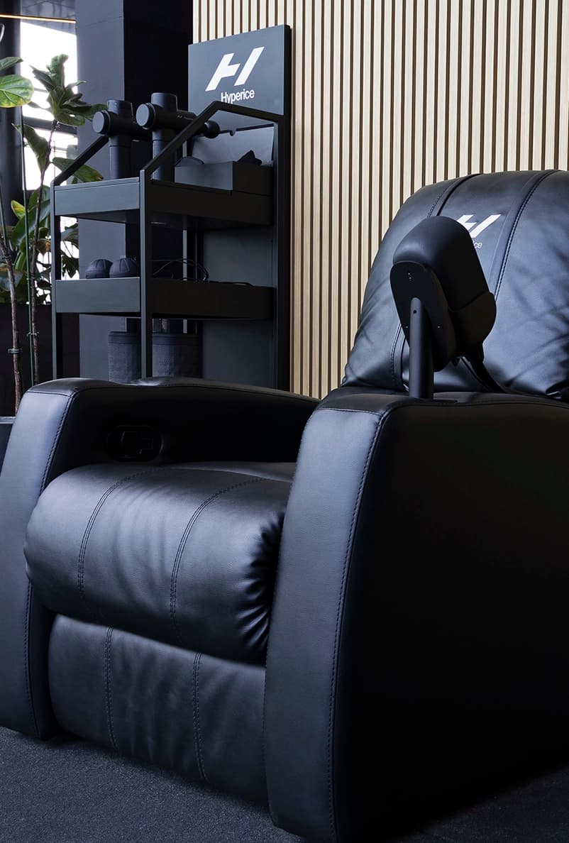 Massagestoel en massage guns bij TrainMore recovery zone.